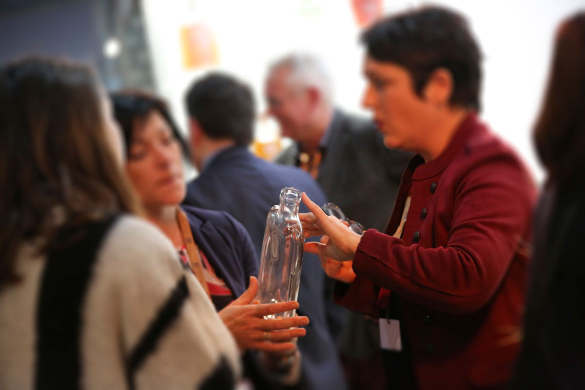 Une exposante présente une carafe pour spiritueux sur son stand à VS Pack